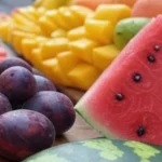 cut fruits in summer heat, street vendor selling cut fruits, refrigerated cut fruits in container, spoiled fruit slices on a plate, healthy summer fruit snacks, bacteria on exposed fruit, safe travel fruit options, insulated bag with fresh fruits, food poisoning from cut fruits
